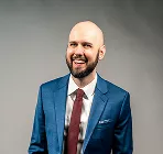 A man in a formal suit stands confidently, showcasing a professional appearance